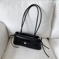 Bolso de hombro negro rectangular con lazo y colgante de corazón en un sofá - Negro