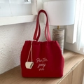 Vista dettagliata della borsa tote in tela rossa con coulisse e scritta ricamata bianca - Rosso