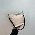 Elegante borsa a secchiello intrecciata crema con tracolla marrone e fibbia argento - Beige