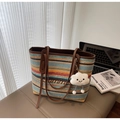 Close-up of colorful striped straw tote with leather straps and cloud charm on a bench - Multicolor Stripes (With Cloud Pendant) / Multicolor With Charm