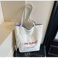 Close-up of cream canvas tote bag with blue striped lining and lace scarf detail - Blue
