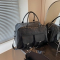 Large black woven travel bag with dual front buckles and adjustable shoulder strap - Black