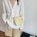 Minimalistische cremegelbe glänzende Leder-Satteltasche für Damen mit rundem Schnallenverschluss - Gelb