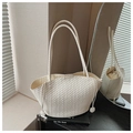 Detail of cream white woven tote bag with drawstring inner pouch on a book - Off White