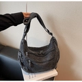 Detail of grey denim hobo bag featuring multiple zip pockets and wide shoulder strap - Black
