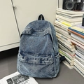 Vintage acid wash blue denim backpack with front zipper pocket in a lifestyle setting - Blue