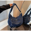 Detail of dark blue denim tote bag featuring multiple zipper pockets and adjustable strap - Dark Blue