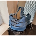 Detail of blue denim tote bag showing multiple front zipper pockets and side pockets - Light Blue