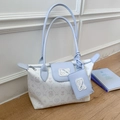 Detail view of large light blue tote bag with cartoon cat patch and matching coin purse - Blue