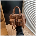 Detail view of brown vintage biker bag showing front pockets and metallic buckle accents - Brown