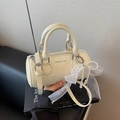 Elegant cream-white cylinder bucket bag with pearl bow charm and adjustable strap - Beige With Pendant