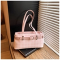 Detalle del bolso tote de cuadros rosas con hebilla metálica sobre un soporte de libros - Rosa