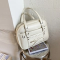 Detail of cream white JK uniform bag featuring heart studs and a decorative bow - White