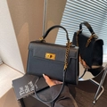 Borsa kelly minimalista in pelle nera con chiusura dorata e tracolla a catena - Nero