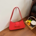 Rote gewebte Achseltasche mit Schleife und Doppelriemen in stilvollem Lifestyle-Ambiente - Rot