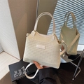 Cream knit bucket bag with leather handles and long shoulder strap in a stylish setup - White