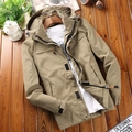 Giacca a vento uomo kaki con cappuccio e tasche su sfondo di legno scuro - M / Cachi
