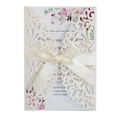 Detalle de invitación de boda calada con láser con lazo rosa e inserto floral suave - Purpurina Marfil