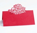 Macro detail of laser-cut red rose flower pattern on wedding place cards - Pearlescent Red