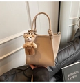 Dettaglio borsa a secchiello in pelle beige con ciondolo a orso e manici tondi - Cachi con Pendente