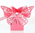 Close-up of pink laser-cut butterfly favor box with intricate patterns and silk ribbon - Pearlescent Red