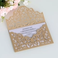 Detail of gold laser-cut wedding invitation with elegant floral hollow patterns - Beige Gold