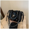 Close-up of black glossy leather bucket bag with silver butterfly clasp and chain strap - Black