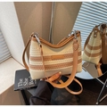 Detail of beige and brown striped crochet bag with leather strap on wooden table - White & Khaki