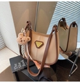 Detail of a vintage crescent shoulder bag with metallic logo and plush bear charm - With Charm / Light Khaki
