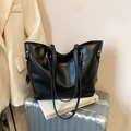 Minimalist black PU leather tote bag with gold hardware on silver suitcase - Black