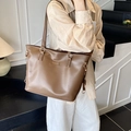Brown PU leather tote bag with Mihuadoudou logo shown from side view on female model - Brown