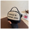 Detail van canvas mini bowlingtas met zwart-wit contrast en tekstuele opdruk - Zwart
