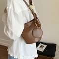 Borsa a secchiello marrone in similpelle con ciondolo portamonete tondo e camicetta bianca - Marrone