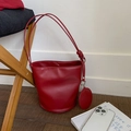 Borsa a secchiello minimalista in pelle rossa con ciondolo tondo e spalline sottili - Rosso