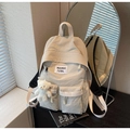 Close-up of beige waterproof nylon backpack with front pockets and cute bear charm - With Charm / Off White