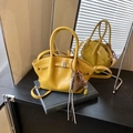 Ginger yellow ruched handbag with dual top handles and heart charm pendant on black book - With Pendant / Yellow