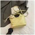 Detail of light green crocodile texture handbag with plush bear charm on white bedding - Yellow with Pendant