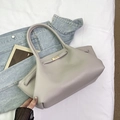 Detail view of the elegant textured leather surface and gold twist lock on the shoulder bag - Light Gray