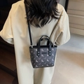 Dark grey bucket bag with star and deer patterns worn with a beige trench coat - Black