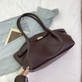 Macro detail of wine red leather tote with gold twist lock and fine grain texture - Reddish Brown