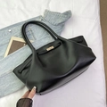 Close-up of black lychee-textured tote bag featuring a polished gold metal twist lock closure - Black