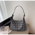 Dettaglio di una borsa hobo a quadri grigi con tracolla in pelle su una scrivania moderna - Nero