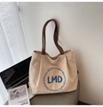 Dettaglio della borsa tote in tela con manici in pelle e ricamo circolare blu - Bianco Sporco