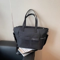 Modern black nylon tote bag with adjustable shoulder strap and NOCO brand logo - Black