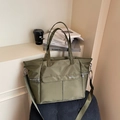 Army green large nylon tote bag with NOCO logo shown in a lifestyle interior setting - Green