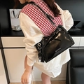Bolso de hombro en charol negro con cadena plateada y detalle de cierre metálico - Negro