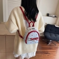 Mini zaino bianco con stampe di fiocchi rossi e spalline in pelle indossato da una modella - Rosso Vino Piccolo