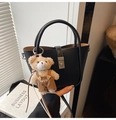 Détail du sac seau en cuir grainé noir avec serrure argentée et breloque ours - Noir avec pendentif
