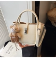 Détail d'un sac seau en cuir beige avec boucle argentée et charmant pendentif en ours - Beige Avec Charme