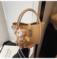 Détail du sac seau beige avec texture litchi, fermoir argenté et pendentif d'ours - Khaki avec Pendentif